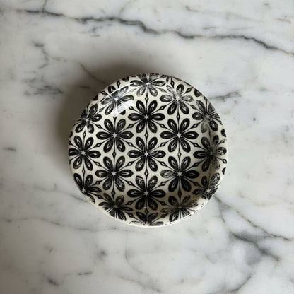Ceramic spoon rest with black and white floral pattern for kitchen counter use