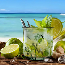 A clear flower embossed recycled glass tumbler with green floral decals filled with mojito ingredients and metal straws