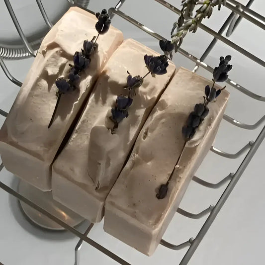  French Lavender shea butter bar soap, features a soothing lavender aroma complemented by bergamot, lemon, and eucalyptus top notes. The artisanal production process ensures each bar has distinctive color variations and unique swirl patterns.