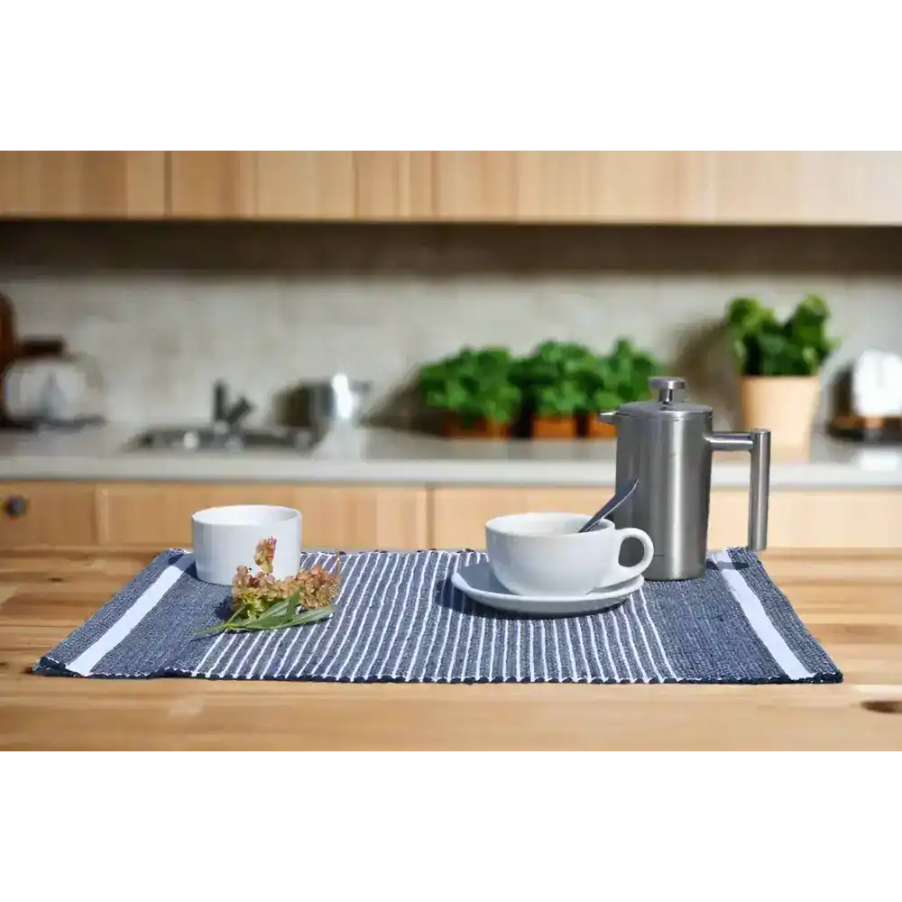Adwa Recycled Cotton Placemat in navy on a stone surface with kitchen scenery in background.