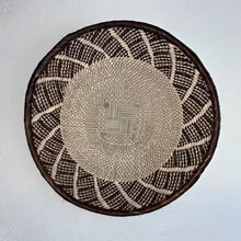 Round woven basket with a pattern on a white background