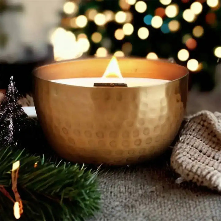 Lit soy candle with wooden wick in a hammered solid brass bowl with crushed thyme herb
