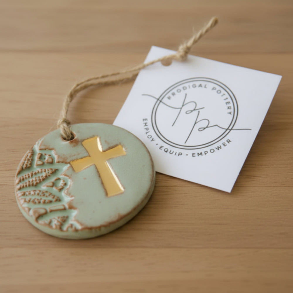 Gold leaf cross ornament in light green ceramic with textured pattern
