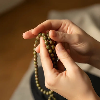 Green unakite mala with beaded tassel featuring smooth 8 mm earthy green and brown beads to support emotional healing