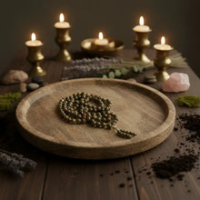 A rustic wooden tray holds a green unakite mala with 8 mm polished beads and a beaded tassel to support emotional healing