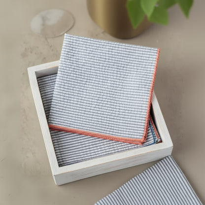 Handcrafted blue gingham napkins with coral edges in rustic box