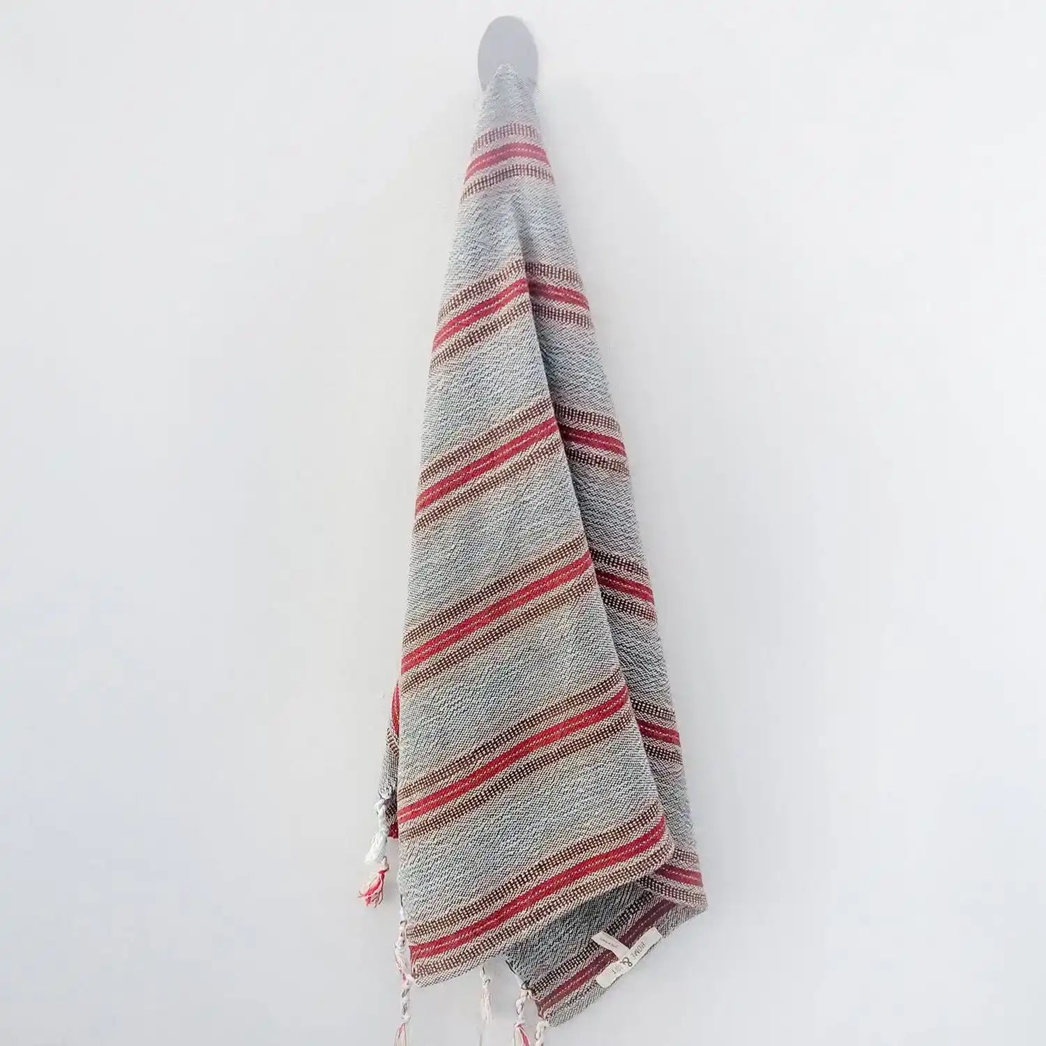Handwoven Turkish hand towel with rust and brown stripes and very thin stripe of turquoise. Finished with hand tied tassels.