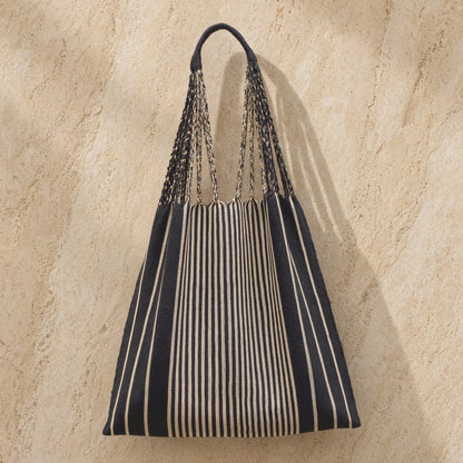 Black and beige hammock tote bag handwoven by indigenous mayan artisans with black and white striped woven design and braided handles