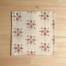 Cream-colored organic cotton napkins with hand block printed red snowflake pattern