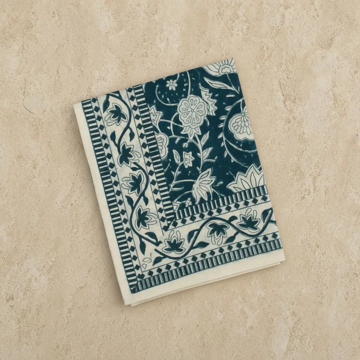 A hand block printed navy blue and white floral organic cotton shaw folded square fair trade table throw