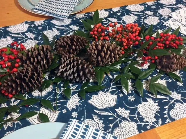 Hand block printed fair trade pinecone and berry table runner on blue patterned fabric