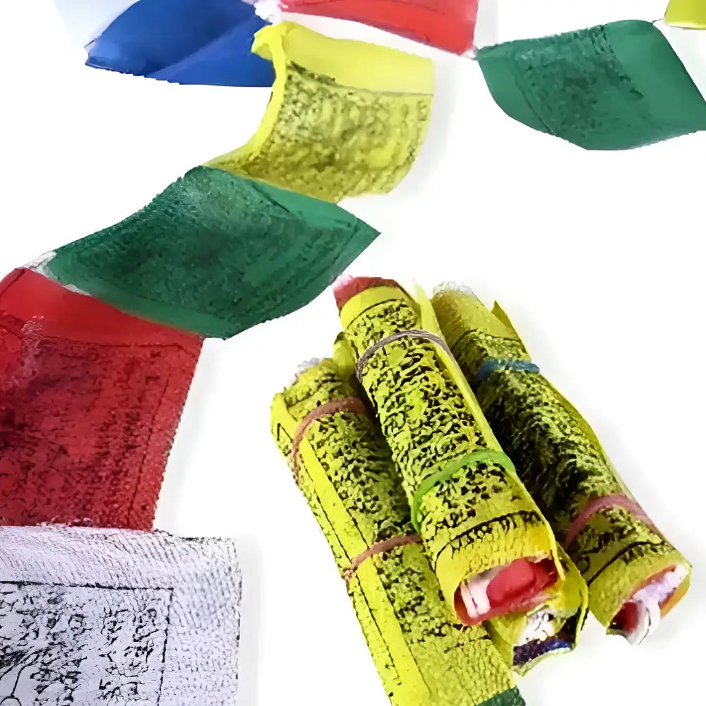 Bright yellow hand block printed tibetan prayer flag strand with black script rolled and tied with colorful elastics