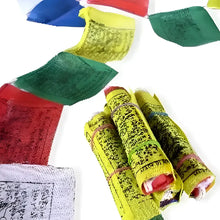 Bright yellow hand block printed tibetan prayer flag strand with black script rolled and tied with colorful elastics