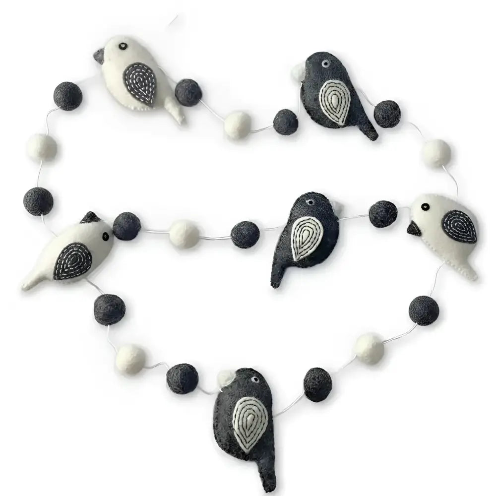 A charming black and white felted wool bird garland with embroidered details perfect as a white bird garland decor