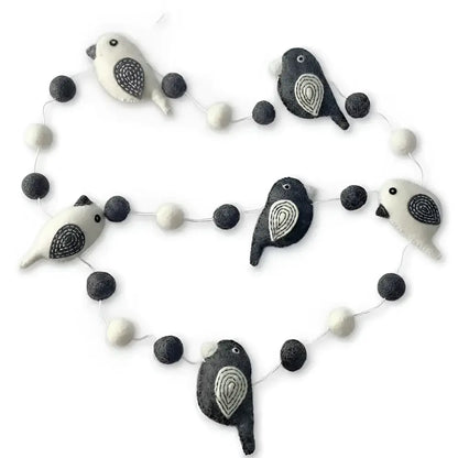 A charming black and white felted wool bird garland with embroidered details perfect as a white bird garland decor