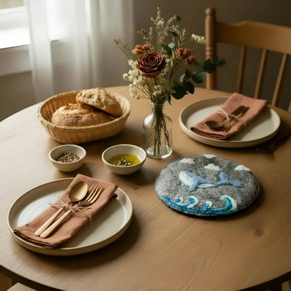 Gray hand-felted wool trivet with blue whale and wave design perfect as a wool trivet or coaster