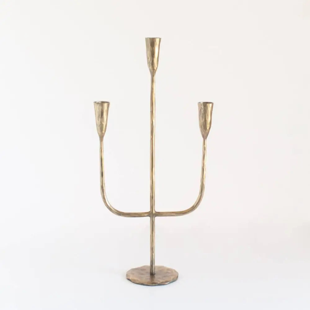 Rustic three-pronged gold hand-forged iron candelabra crafted by expert blacksmiths for premium feel decor