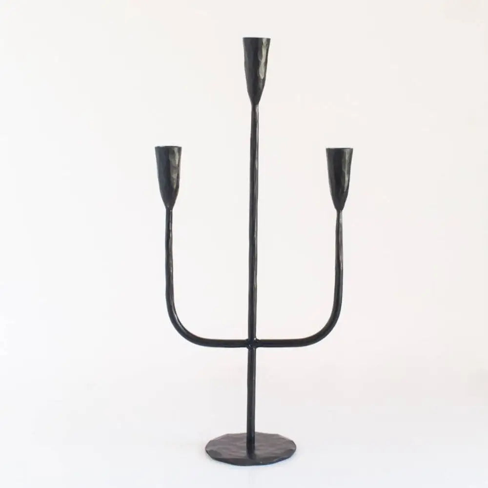 Black metal three-taper candle holder from hand-forged iron candelabra by expert blacksmiths