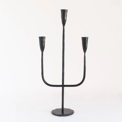 Black metal three-taper candle holder from hand-forged iron candelabra by expert blacksmiths