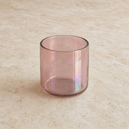 A handblown cocktail glass in translucent rose gold with an iridescent sheen and a lustrous finish that catches light
