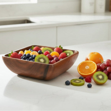 A rustic handcrafted acacia wood square salad bowl filled with colorful fresh fruits