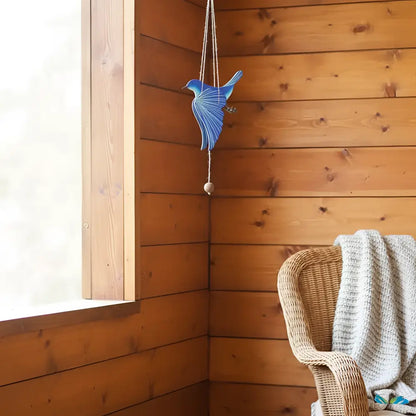 Handcrafted blue bird flying mobile with a textured layered design and small wooden bead for happiness creates ethical décor