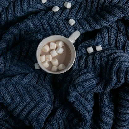 Handcrafted white mug with marshmallows on eco-friendly blue herringbone knit shawl