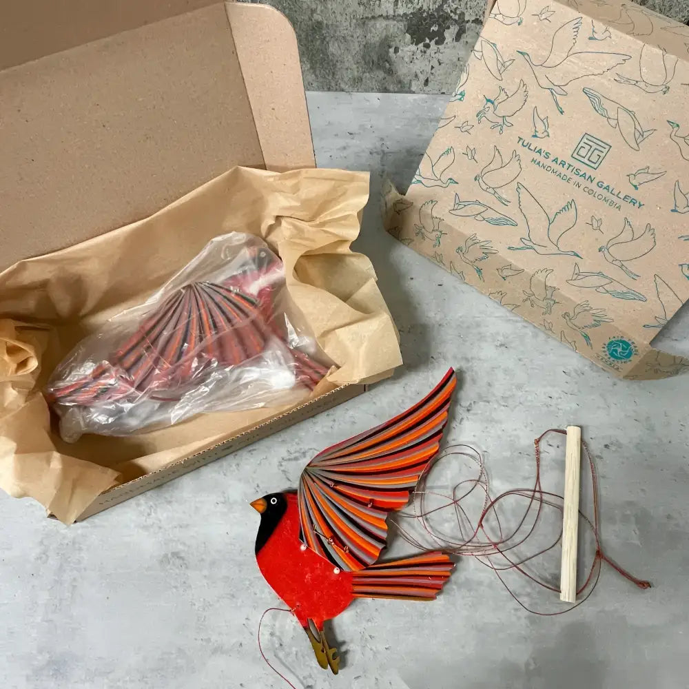 Handcrafted cardinal mobile with vibrant red orange striped paper bird puppet and wooden feet for playful flutter and perfectly balanced flight