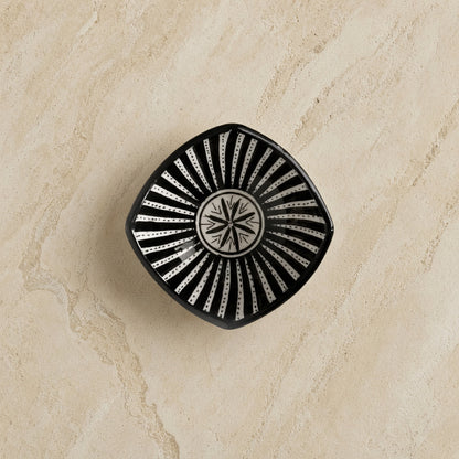 Black handcrafted ceramic bowl from safi morocco with white sunburst star pattern inspired by rugged atlantic design