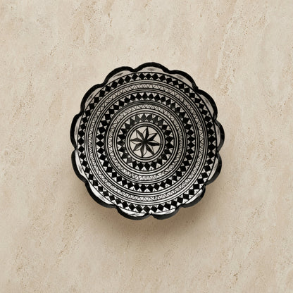 Handcrafted ceramic bowl from safi morocco with black geometric patterns and a scalloped edge inspired by rugged atlantic