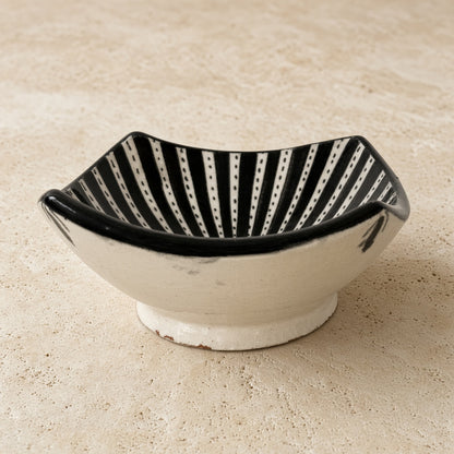 Handcrafted ceramic bowl from safi morocco with white exterior black interior and bold rugged atlantic black patterns