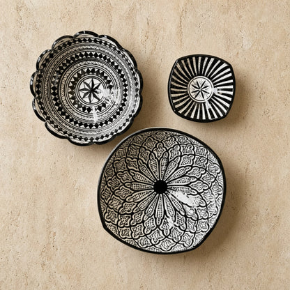 Three black and white handcrafted ceramic bowls from safi morocco with intricate geometric and floral black patterns
