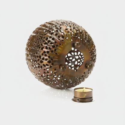 Handmade eco-friendly bronze sea urchin-shaped candle holder with perforations and a central opening