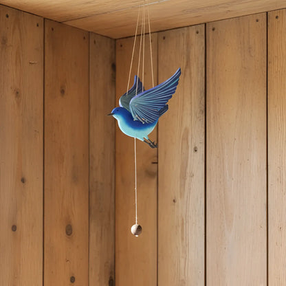 Handcrafted blue bird flying mobile with detailed wing feathers and a hanging wooden bead for happiness creates ethical decor