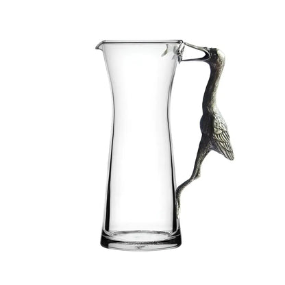 Handcrafted glass pitcher with pewter crane handle for elegant, eco-friendly beverage serving