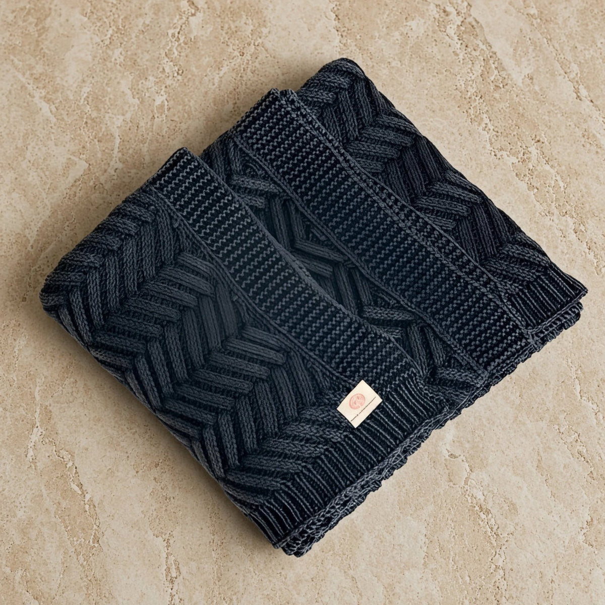 Handcrafted navy blue chevron throw blanket featuring dark gray herringbone knit with tactile luxury and artisanal craftsmanship