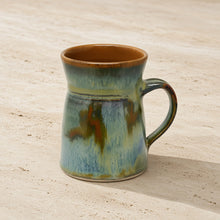 Handcrafted pottery flare mug with unique tapered shape in green blue and brown mottled glaze with northern light vibes