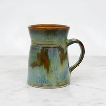Handcrafted pottery flare mug with a unique tapered shape and northern light vibes in green blue and brown glossy ceramic