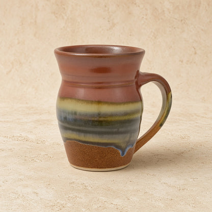 Handcrafted pottery mug aztec sunrise with rustic brown green blue glaze stripes and sunrise vibes drip design