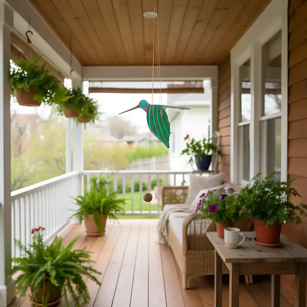 Handcrafted handmade vibrant green ruby throated hummingbird wind chime with teal and purple accents hanging outdoors