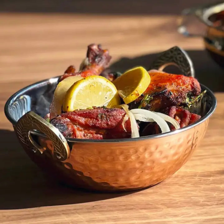 Hammered copper Handi Double Wall Serving Bowl with roasted chicken lemon slices and onion