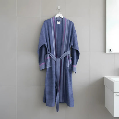A soft blue and purple striped cotton robe with matching belt hanging on a white hanger by skilled artisans indigo tribeca handmade beautiful design