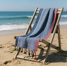 Handloomed turkish cotton bath towel with indigo tribeca handmade blue white and red stripes draped over wooden chair