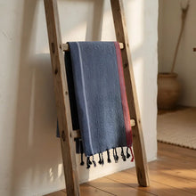 Handloomed turkish cotton bath towel with indigo blue and red stripes hanging on wooden ladder by skilled artisans