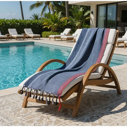 Handloomed turkish cotton bath towel with indigo blue white and red stripes draped on wooden lounge chair by skilled artisans