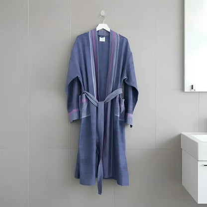 A soft lavender-blue bathrobe with lighter blue and purple stripes paired with a handmade turkish cotton hand towel