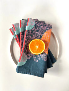 Colorful handmade eco-friendly blue linen dinner napkins set with bright orange slice