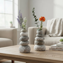 Handmade eco-friendly cairn vase with lavender, orange flowers, and stacked gray stones
