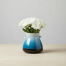Handmade ceramic vase with blue and white gradient, white flowers, black accents and handles