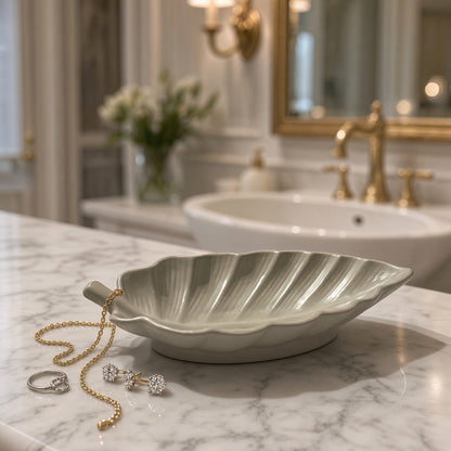 A light gray handmade concrete arabica leaf dish with ridged detailing perfect for corralling soap or small items